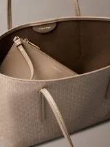 Cartera tote de Calvin Klein en color beige, con estampado de monograma CK repetido en toda la superficie, doble asa fija y diseño estructurado.