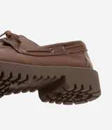 Zapato estilo dockside de cuero color marrón, con puntera redonda, cordones frontales y suela track dentada.