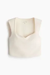 Top deportivo cropped H&M Move en tejido funcional color beige con tecnología SculptMove™ y DryMove™. Presenta escote corazón, soutien incorporado con relleno extraíble y corte ajustado.