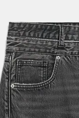 Jeans de tiro medio con cinco bolsillos, cintura doble a contraste y detalles de rotos. Cierre frontal con cremallera y botones metálicos.