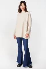 Sweater crudo de punto con cuello alto y mangas largas con puños ajustados.