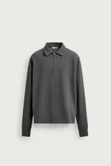 Polo de manga larga color gris oscuro, con diseño de textura estructurada, cuello solapa y cierre frontal de cremallera corta. Cuenta con puños y cintura de rib elástico.