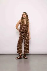 Blusa marrón con lunares blancos, escote en V y sin mangas.