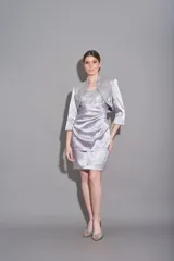 Vestido corto plateado, de corte recto y sin mangas. Incluye chaqueta de seda haciendo juego, con tul bordado.