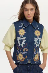 Chaleco de denim azul oscuro con cuello clásico y bordados florales en tonos amarillos, blancos y celestes en la parte delantera.