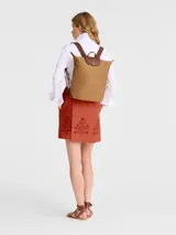 Mochila Longchamp modelo Le Pliage Original en tamaño M, color tostado. Presenta un diseño minimalista con solapa y asas de cuero marrón, cierre principal con solapa de botón a presión y correas ajustables de tela.