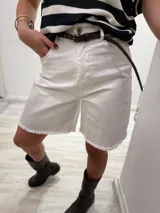 Bermuda color borgoña de gabardina elastizada, corte a la rodilla, con cinto fino con tachas y detalles de flecos en el ruedo.