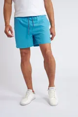 Short de baño color turquesa con cintura elástica y cordón ajustable. Presenta bolsillos laterales y un bolsillo trasero, con el logo de la marca bordado en la parte inferior de la pierna.