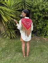 Camisa de jean con diseño estilo western, featuring un canesú trasero con estampado paisley en blanco y azul, y flecos largos de cuero rojo. Cuenta con mangas largas abullonadas con puños elásticos fruncidos.