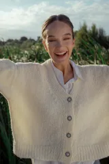 Cárdigan tejido en boucle color crudo, de corte holgado y mangas largas.