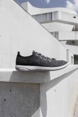 Zapatilla de diseño minimalista confeccionada en lana merino, con cordones al tono y suela de EVA. Presenta un estilo atemporal y versátil, ideal para uso diario.