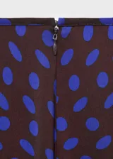 Pantalón de tiro medio con diseño flare y largo, con cierre de cremallera lateral y estampado de lunares.