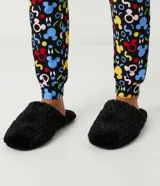 Pantufla cerrada de mujer con textura de peluche suave en color negro, diseñada para brindar comodidad en el hogar.