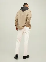 Pantalón de jean color beige, corte recto, con cinco bolsillos y cierre de cremallera.