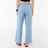 Pantalón vaquero de corte ancho y relajado, color azul claro, con cintura elástica fruncida y cordón ajustable.
