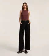 Pantalón de vestir negro, modelo pantalona de tiro alto, con pliegues frontales, bolsillos laterales y cinturón a juego.