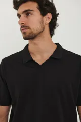 Chomba negra de piqué con cuello clásico y mangas cortas.