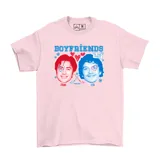 Remera de algodón color rosa con estampado gráfico frontal que presenta los rostros de dos hombres, corazones, copos de nieve y palos de hockey cruzados, junto con la inscripción 'Boyfriends'.