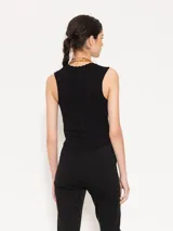 Top color borgoña de hilado frío, corte ajustado y largo hasta la primera cadera. Sin mangas, con cuello redondeado y profundo.