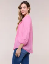Blusa de silueta suelta color azul, con escote en V y cuello mao. Cuenta con abotonadura frontal, alforzas verticales en el pecho y mangas tres cuartos con puños elastizados.