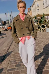 Trench corto de Zara confeccionado en piel de ante, con cuello de solapa, cierre frontal cruzado con botones, mangas largas con trabillas y bolsillos delanteros de vivo.