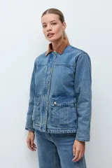 Campera de jean en tono azul medio, con cuello de pana en color marrón, cierre frontal con botones metálicos y bolsillos frontales tipo cargo.