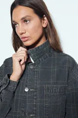 Sobrecamisa de algodón con estampado de cuadros, corte relajado, bolsillos frontales y cuello de pana en contraste. Cuenta con cierre frontal de botones y diseño de estilo utilitario.