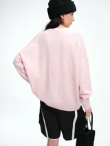 Cardigan de punto color marrón con textura jaspeada, escote en V, cierre frontal con botones y diseño de hombros caídos.