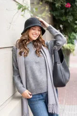 Cárdigan gris de tejido de punto acanalado, con cuello alto, cierre de cremallera corto y corte holgado.