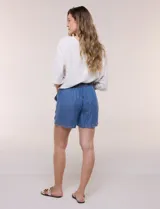 Short verde militar de tiro medio, confeccionado en lyocell con cintura elastizada y cordón tubular de ajuste con punteras metálicas. Cuenta con amplios bolsillos delanteros aplicados y diseño holgado.