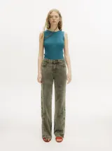 Pantalón de jean de corte recto y tiro medio, con efecto gastado. Presenta una hilera de botones en los laterales de los botapiés y bolsillos delanteros y traseros.