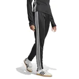 Pantalón deportivo Adidas Tiro 25 Essentials de corte ajustado, color negro con las icónicas tres tiras blancas laterales. Cuenta con pretina elástica con cordón de ajuste, bolsillos laterales con cierre y tecnología AEROREADY para mayor transpirabilidad.