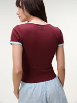 Remera baby tee de manga corta, color gris melange, con calce ajustado y cuello redondo.