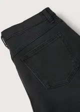 Jeans mom-fit de tiro alto color negro, confeccionados en denim elástico con diseño de cinco bolsillos y trabillas para cinturón.