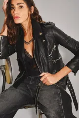 Campera de cuero ovino con diseño estilo motoquero, solapas, charreteras en los hombros y cierres metálicos plateados en frente, puños y bolsillos.