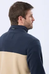 Buzo polar bicolor de hombre, con diseño en negro en la parte superior y gris en la inferior. Cuenta con cuello alto, cierre frontal medio y bolsillos laterales con cierre.