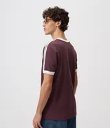 Remera celeste de corte regular, con cuello redondo, mangas cortas y detalles de rayas blancas en los hombros. Cuenta con terminaciones en tono contrastante en cuello y puños.