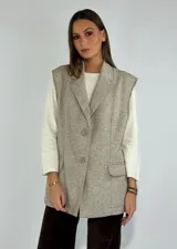 Chaleco crudo con solapas, sin mangas y cierre frontal con dos botones.