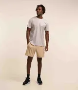 Remera deportiva de hombre, color gris claro, con cuello redondo y manga corta. Presenta un sutil efecto degradado o panel de color más claro en la zona del pecho.