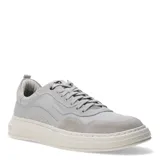 Championes urbanos Democrata modelo Triada, color gris, confeccionados en una combinación de cuero liso y gamuza. Presentan cierre con cordones, suela de goma texturizada en tono crema y logo de la marca grabado en el lateral y en la suela.