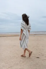 Túnica a rayas verticales anchas color gris y blanco, con mangas cortas y lazo en la cintura.