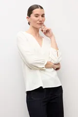 Blusa negra de manga larga con diseño de tejido plumeti y escote en V.