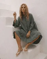 Vestido midi de lino color verde militar, con cuello mao, cierre frontal de botones, mangas largas abullonadas y volados en el ruedo.