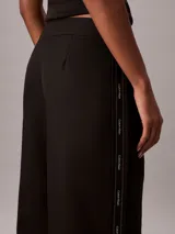 Pantalón de pierna ancha color negro, confeccionado en sarga de algodón, con cintura elástica y diseño moderno.