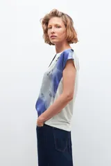 Blusa de mangas cortas con estampado abstracto en tonos blanco, azul y negro.