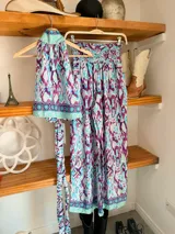 Conjunto de dos piezas color fucsia con estampado oriental en tonos rosa y blanco, compuesto por un top halter con lazo en la cintura y un pantalón palazzo de cintura alta con elástico.