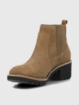 Bota tipo Chelsea de Hush Puppies, confeccionada en material sintético efecto gamuza color marrón. Presenta elásticos laterales al tono para facilitar el calce, suela robusta de goma negra con plataforma y taco ancho.