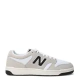 Championes New Balance 480 Court de estilo retro inspirado en el básquet, con exterior de cuero blanco y refuerzos de gamuza en tono gris claro. Presenta el logo N en color negro en los laterales, cordones blancos y suela de goma con base negra.