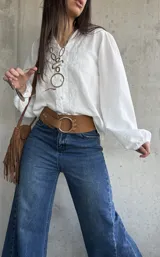 Camisa blanca de manga larga abullonada, con delicados bordados frontales y cierre con botones.