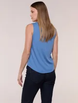 Musculosa blanca de tejido acanalado, con escote redondo adornado con tachas metálicas en el borde y breteles anchos.